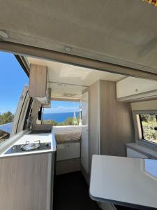 una cocina en una cabaña con vistas al océano en Beautiful Campervan (Mallorca), en Sant Francesc