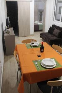 een woonkamer met een tafel met borden en wijnglazen bij Ranias's House 2 in Piraeus