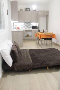 een bank in een woonkamer met een tafel en een keuken bij Ranias's House 2 in Piraeus