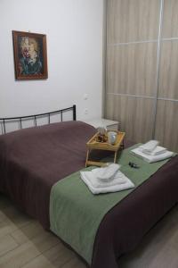 een slaapkamer met een bed met twee handdoeken erop bij Ranias's House 2 in Piraeus