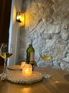 een fles wijn en twee glazen op een tafel bij Apartment Stone Mostar in Mostar