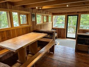 einen großen Holztisch in einem Zimmer mit Fenstern in der Unterkunft Puelo Libre in Llanada Grande
