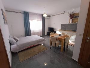 Zimmer mit einem Bett und einem Tisch sowie einer Küche in der Unterkunft Apartments Poljanak Green House in Plitvička Jezera