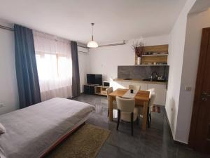 ein Schlafzimmer mit einem Bett und einem Tisch sowie eine Küche in der Unterkunft Apartments Poljanak Green House in Plitvička Jezera