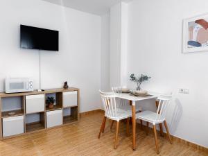 a white dining room with a table and chairs at Sea Estudio Cala de Mijas in La Cala de Mijas