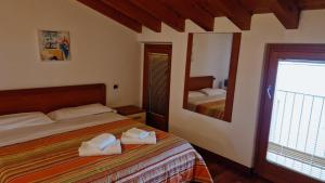 1 dormitorio con 1 cama con toallas en Apartments Tony in Bardolino, en Bardolino