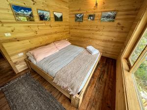 1 dormitorio en una cabaña de madera con 1 cama. en Puelo Libre en Llanada Grande