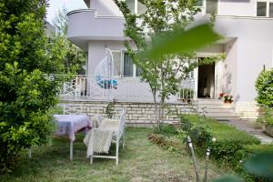 a table and chairs in the yard of a house at Rooms by Romi in Durrës