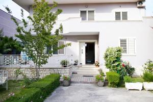 a white house with a front yard with plants at Rooms by Romi in Durrës