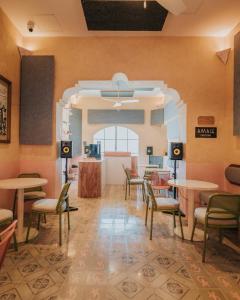 - une salle d'attente avec des tables et des chaises dans un restaurant dans l'établissement Casa Amate 61 Boutique Hostel, à Mérida