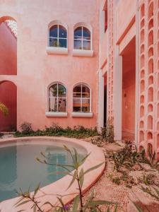 an external view of a building with a swimming pool at Casa Amate 61 Boutique Hostel in Mérida