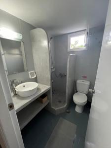a bathroom with a sink and a toilet and a window at Spanos Apartments - Panteli in Panteli