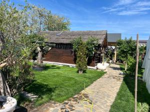 a garden with a house with a hose at Cabana Maya in Corbu
