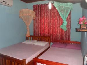 
a bedroom with a bed and a dresser at Thisal Guest House in Polonnaruwa
