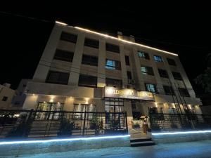 budynek z oświetleniem przed nim w nocy w obiekcie Golden Palace Hotel Apartments w mieście Amman