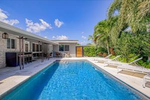 a swimming pool in front of a house at Designer Delight in Fort Lauderdale