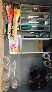 un cajón de la cocina lleno de utensilios y otros artículos en Le Wilson - accès Paris facile !, en Limeil-Brévannes