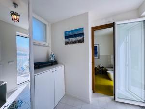 a bathroom with a sliding glass door to a bathroom with a toilet at YourHome - White House Giò in Positano +18 photos