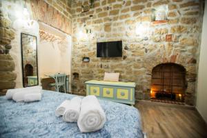 a bedroom with a stone wall with a bed and a fireplace at The Cave in Naples