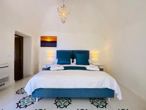 a bedroom with a large bed with blue pillows at YourHome - White House Giò in Positano