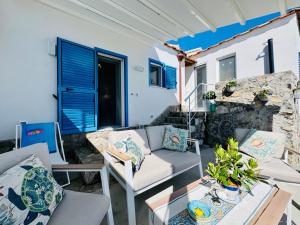 a patio with a couch and chairs and a table at YourHome - White House Giò in Positano