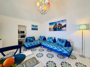 a living room with blue couches and a chandelier at YourHome - White House Giò in Positano