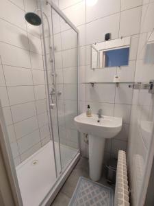 a white bathroom with a sink and a shower at Hotel Le Bon Moine in Reims +27 photos