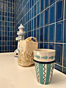 a couple of cups sitting on a counter in a bathroom at La Canadienne in Courseulles-sur-Mer