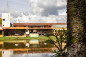 um edifício com um lago em frente em Goldmen Hotel Fazenda em Guarapuava