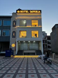克勒尔Hotel imperia的坐在建筑物前的摩托车上的人