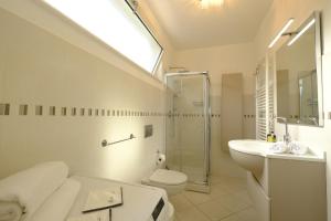 La salle de bains est pourvue de toilettes, d'un lavabo et d'une douche. dans l'établissement MIMA61 - Appartamento con giardino e posti auto a 50mt dal centro, à Milano Marittima