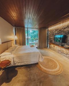 a bedroom with a large bed and a flat screen tv at Vila Baru in Alto Paraíso de Goiás +57 photos