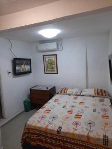 sypialnia z łóżkiem i telewizorem w obiekcie Hostal Casa de las Americas w mieście Cartagena de Indias