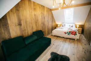 um quarto com uma cama e um sofá verde em Apartamenty Rogoża em Rogożnik