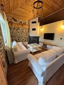 een woonkamer met witte banken en een tv bij Cozy House Nipsa in Nípsa