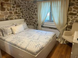 een bed in een kamer met een stenen muur bij Cozy House Nipsa in Nípsa