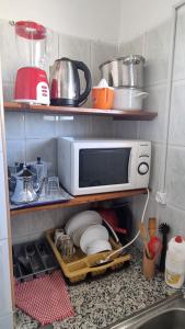 a kitchen counter with a microwave on a shelf at Apartamento Vista Mar in Martil