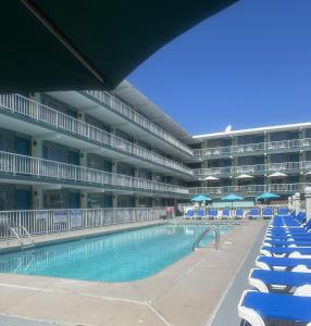 an empty swimming pool in a large building with blue chairs at Royal Canadian Motel in Wildwood