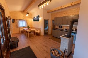 a kitchen and dining room with a wood stove at Chaty pod lesom Oščadnica in Oščadnica