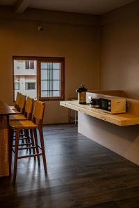 a kitchen with chairs and a counter with a microwave at Miki House in Chumphon