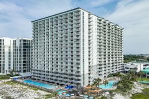 een groot wit gebouw met een zwembad ervoor bij Pelican Beach Resort 405 in Destin