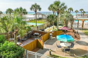 een patio met een tafel en een parasol en het strand bij Pelican Beach Resort 405 in Destin