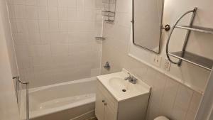 uma casa de banho branca com um lavatório e uma banheira em Incentra Village Hotel em Nova York