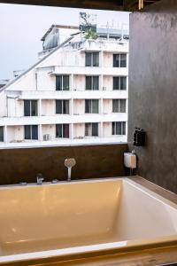 a bath tub in a room with a building at Miki House in Chumphon