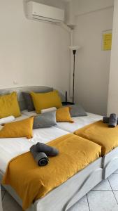2 letti con cuscini gialli in una stanza di ALEKA KOTSI ROOMS a Igoumenítsa
