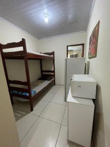 Zimmer mit 2 Etagenbetten und einem Kühlschrank in der Unterkunft Dom Antonio 3 in Campos dos Goytacazes