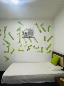 ein Schlafzimmer mit einer weißen Wand mit grüner Schrift in der Unterkunft heritage bunglow by silk five in Avissawella