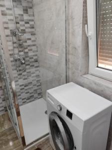eine Waschmaschine im Bad mit Dusche in der Unterkunft Kuca Imotski in Imotski