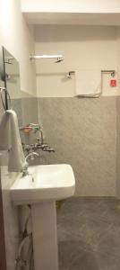 W łazience znajduje się biała umywalka i lustro. w obiekcie Yummly land guest house w mieście Imphal