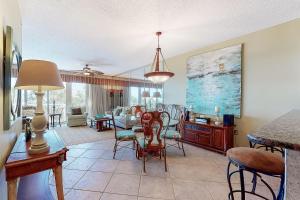 a dining room and living room with a table and chairs at The Crescent 104 in Destin